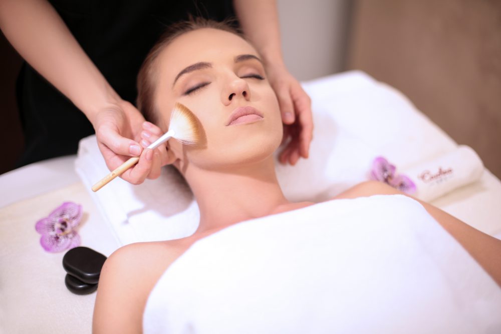 Facial treatment with golden brush and orchids