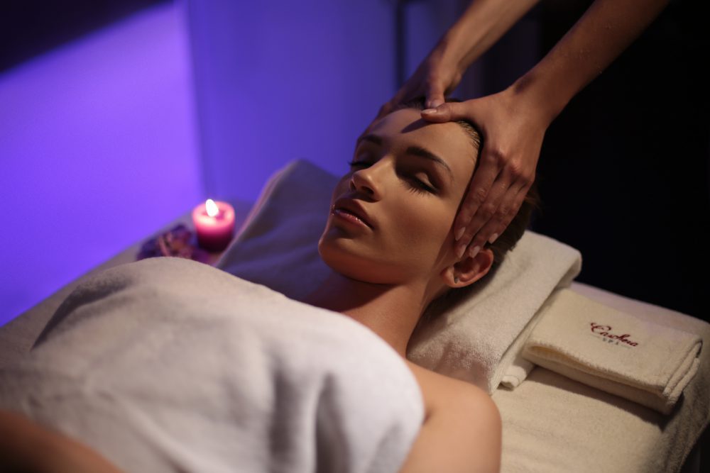 Facial massage in environment with purple lights