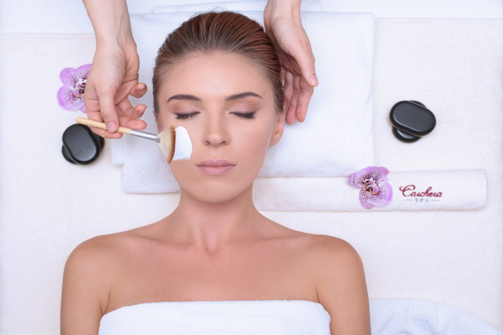 Facial treatment with brush and hot stones